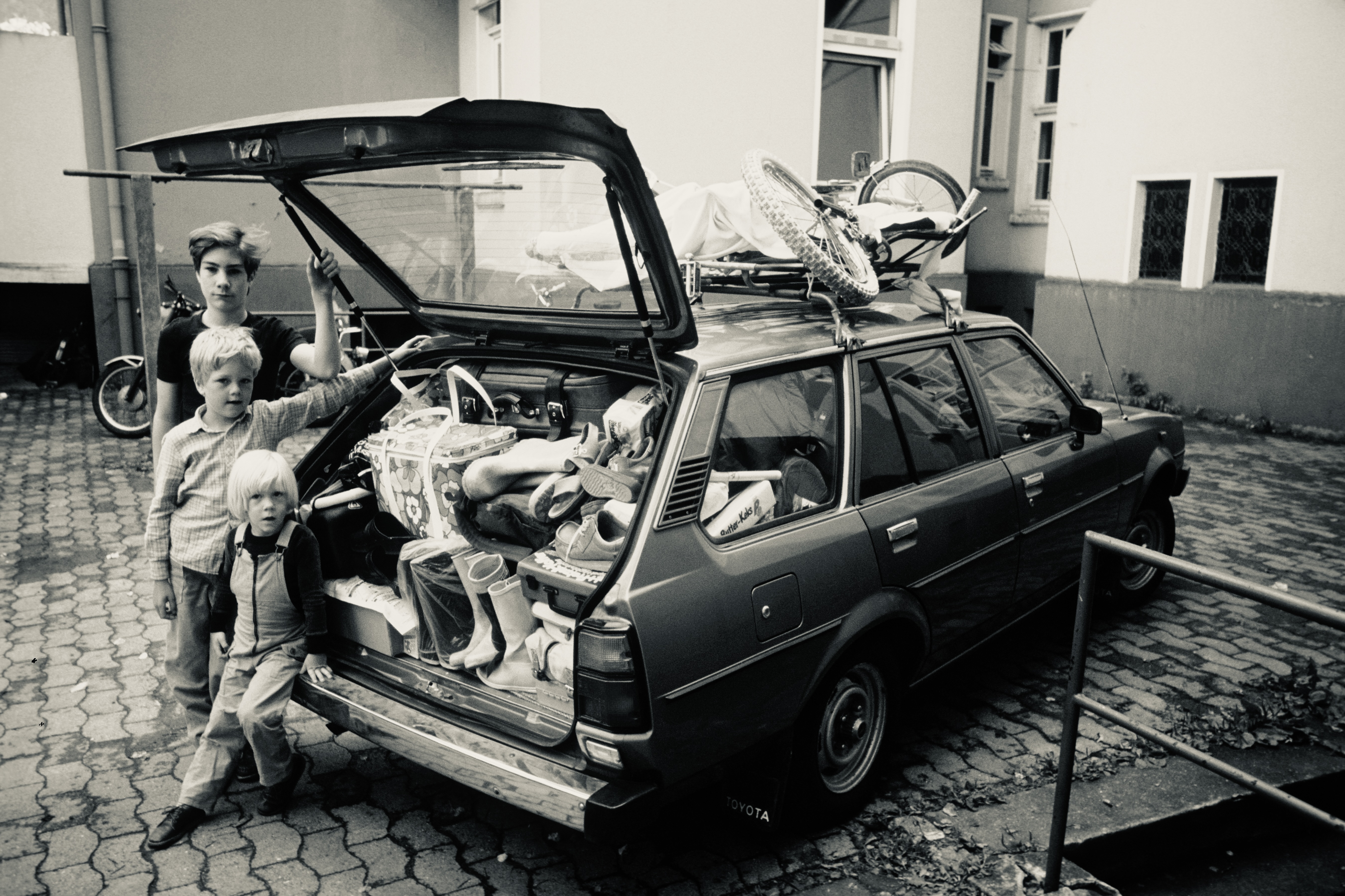 Roman und Philipp als Kinder am vollgepackten Kombi